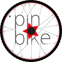 Una ruota di bicicletta con la scritta "pin * bike" incastrata fra i raggi